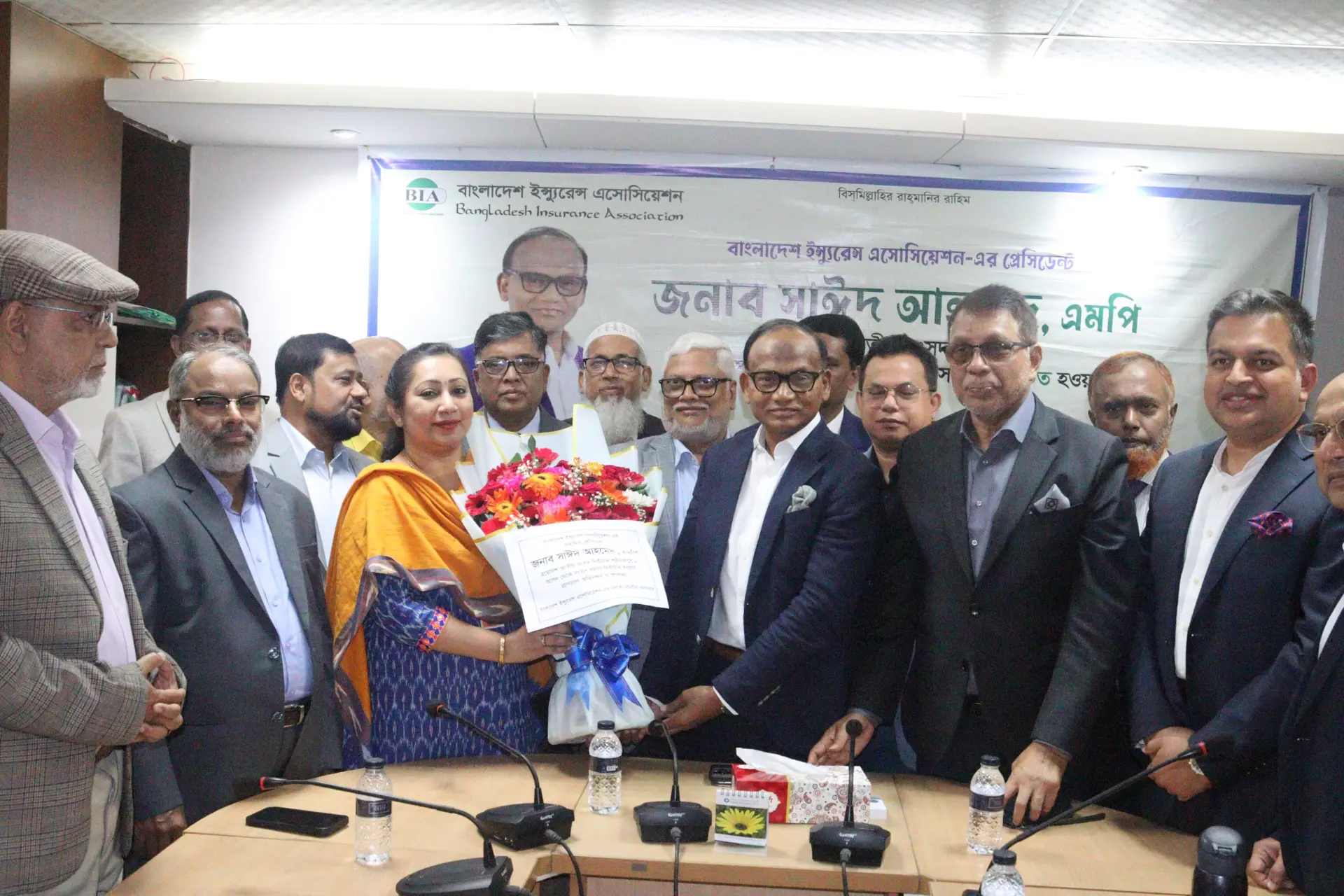 Guests presenting flowers to the President of the Bangladesh Insurance Association at a programme