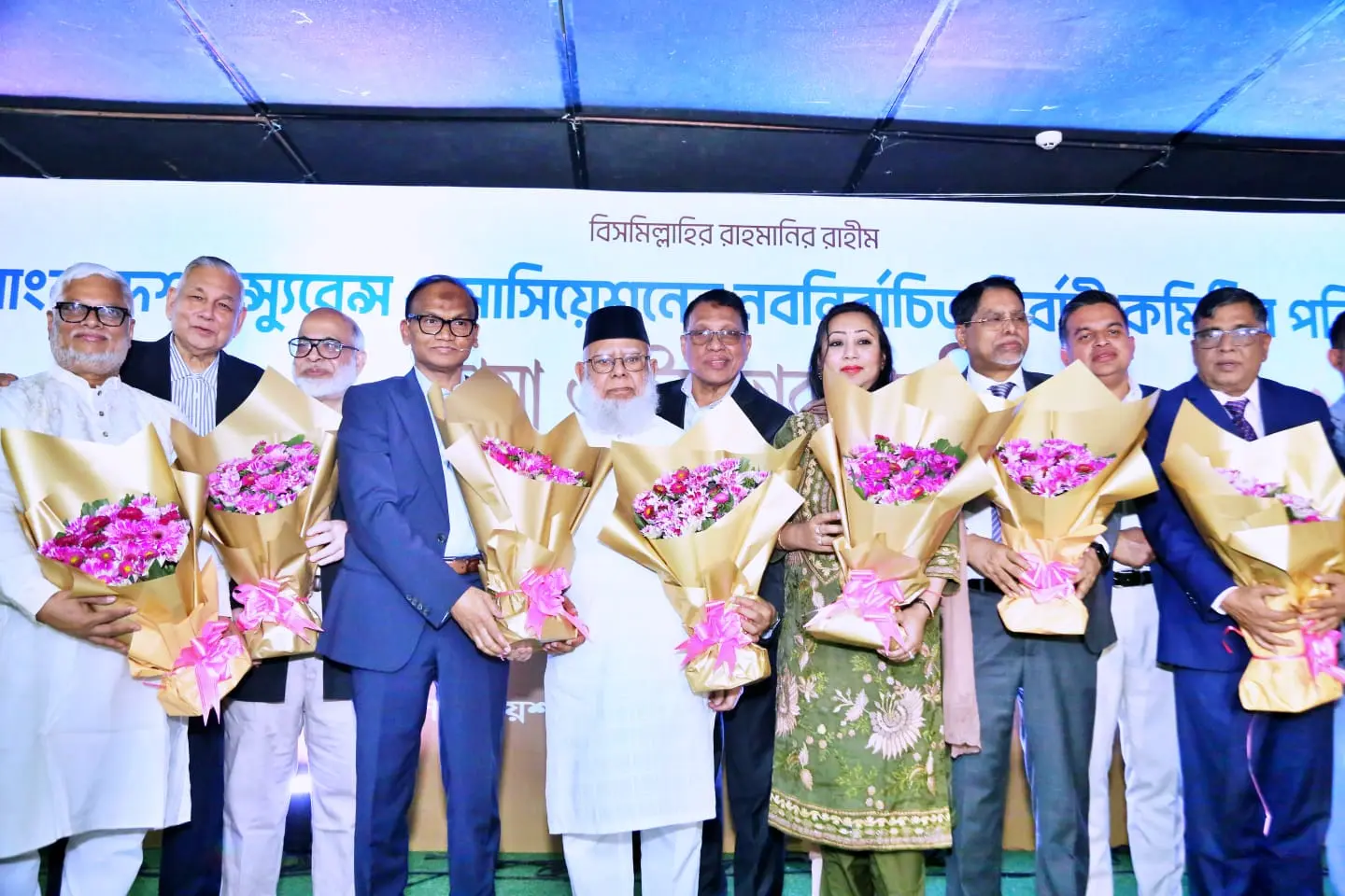 Newly elected executive committee members of the Bangladesh Insurance Association holding bouquets on stage